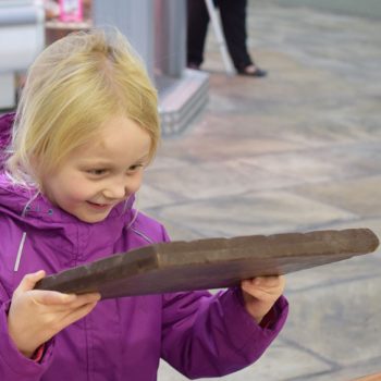 young-girl-holding-massive-bar-of-chocolate
