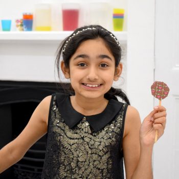 young-girl-holding-up-the-chocolate-lollipop-she-made